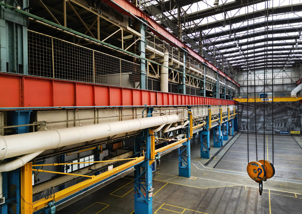 Industriële hal van KMS met rode staalconstructie en blauwe kolommen